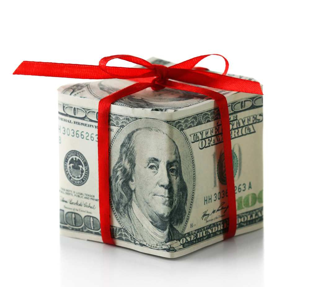 Hundred dollar bill folded like gift box with bow